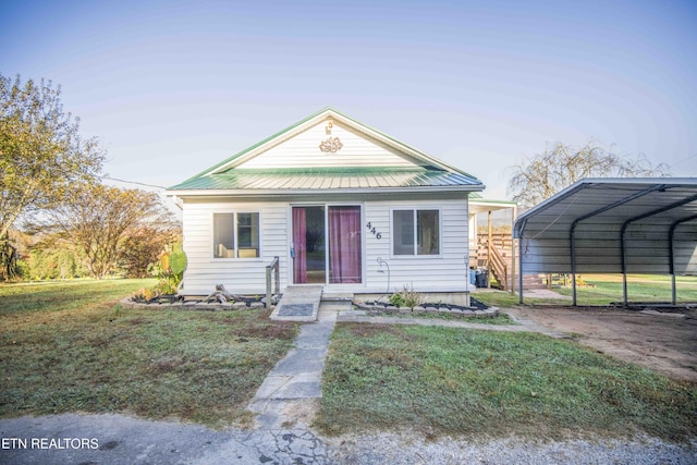 view of front of house with driveway, metal roof, a front yard, and a carport