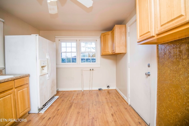 laundry room featuring ceiling fan, cabinets, and light hardwood / wood-style flooring