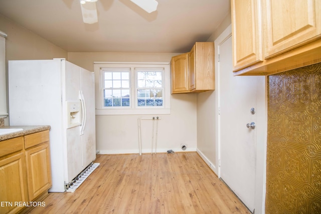 clothes washing area featuring cabinet space, ceiling fan, baseboards, and light wood-style flooring
