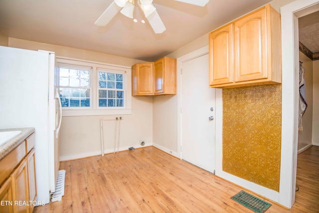 laundry area featuring light hardwood / wood-style flooring, cabinets, and ceiling fan