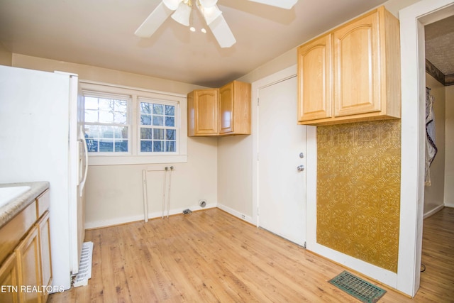 laundry area featuring light wood-style floors, a ceiling fan, cabinet space, and visible vents