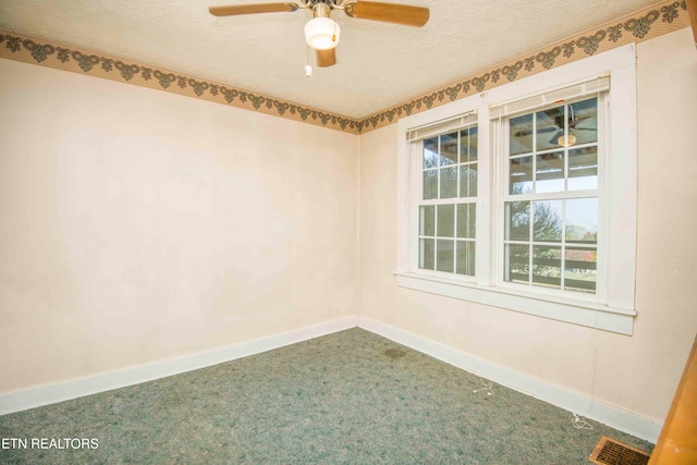 carpeted spare room featuring a textured ceiling and ceiling fan