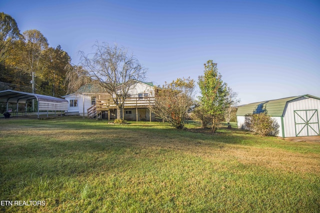 view of yard with stairs, a storage shed, a wooden deck, an outbuilding, and a carport