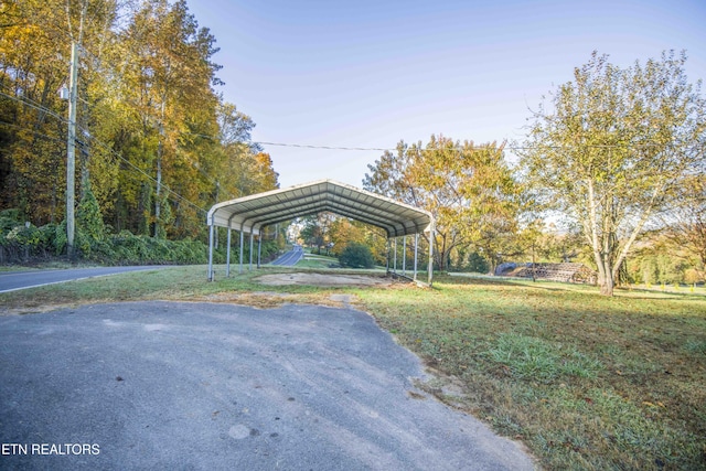 view of community featuring a lawn, driveway, and a carport