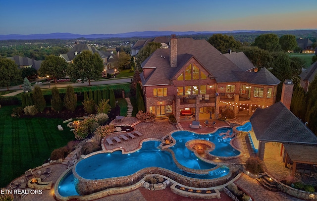 pool at dusk featuring a patio