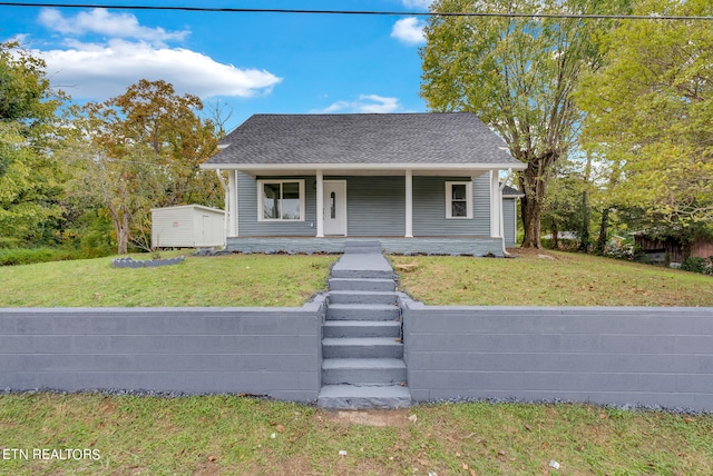 bungalow with a front yard, a shed, and a porch