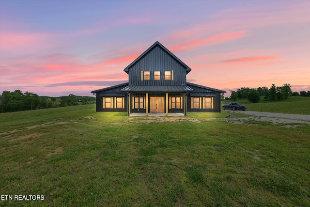 back house at dusk with a lawn