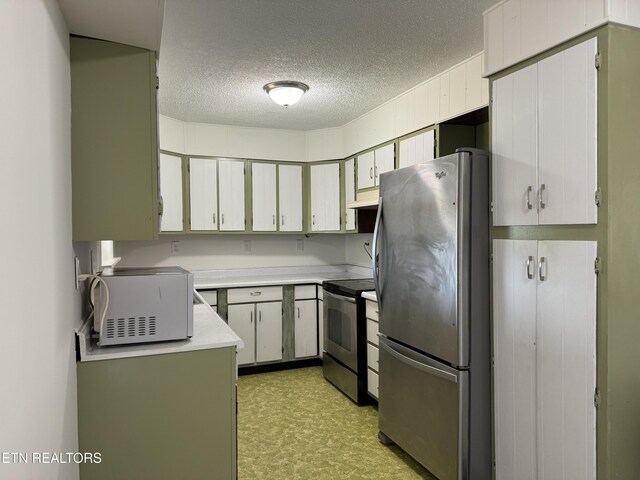 11806 Dry Valley Rd, Loudon, TN 37774 - kitchen with appliances with stainless steel finishes, under cabinet range hood, light countertops, a textured ceiling, and light floors