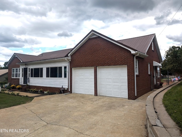 1005 Monroe St, Sweetwater, TN 37874 - view of front facade with a garage, driveway, metal roof, and brick siding
