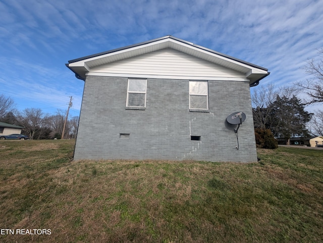 view of side of home with a lawn