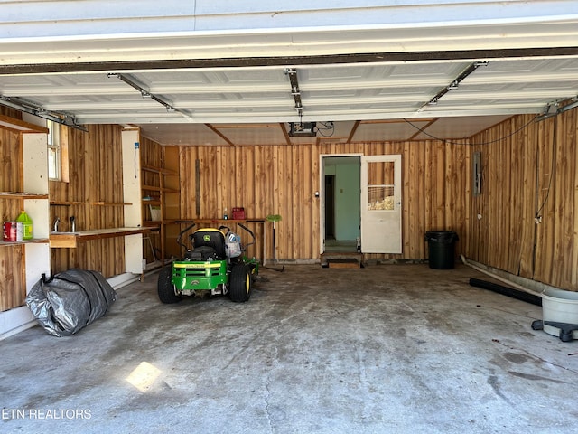 garage featuring a garage door opener and wooden walls