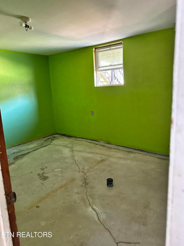 spare room featuring concrete floors and a textured ceiling