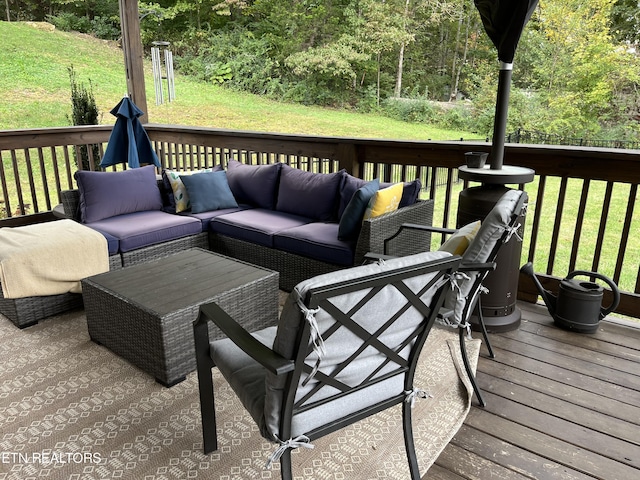 deck featuring a lawn, a forest view, and an outdoor living space