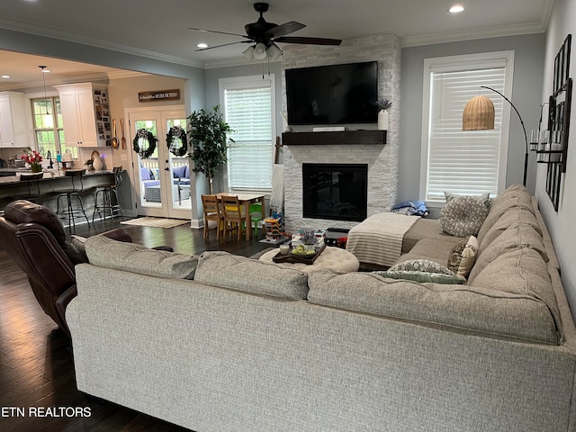 living room with crown molding, dark wood-type flooring, and a wealth of natural light