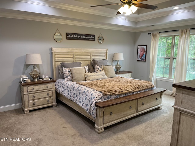 bedroom featuring crown molding, a tray ceiling, carpet, and ceiling fan