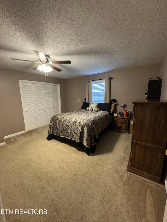 bedroom featuring carpet flooring, a textured ceiling, a closet, and ceiling fan