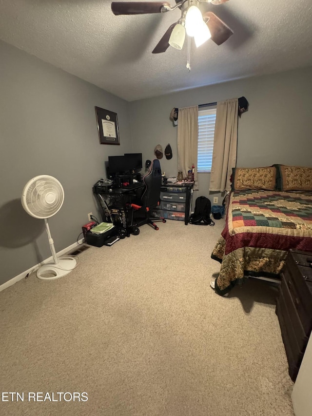 carpeted bedroom featuring a textured ceiling and ceiling fan