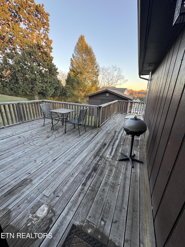 deck at dusk featuring area for grilling