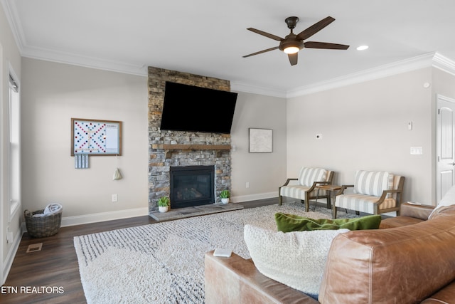 living room with a stone fireplace, ornamental molding, dark hardwood / wood-style floors, and ceiling fan