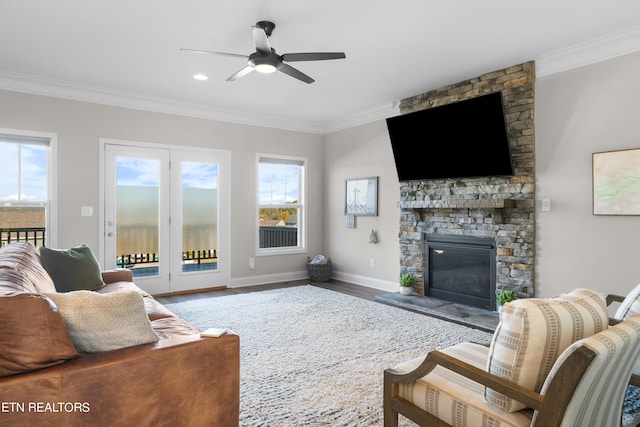 living room with crown molding, hardwood / wood-style floors, a fireplace, and a wealth of natural light