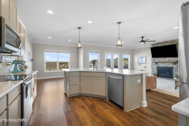 kitchen featuring appliances with stainless steel finishes, a center island, pendant lighting, and dark hardwood / wood-style flooring