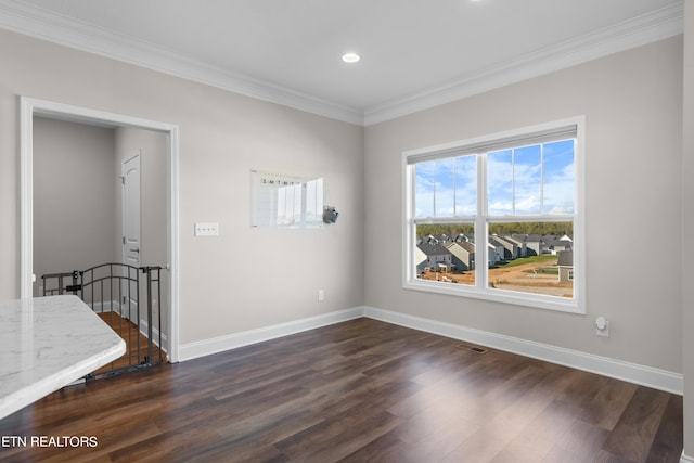 empty room with dark wood-type flooring and ornamental molding