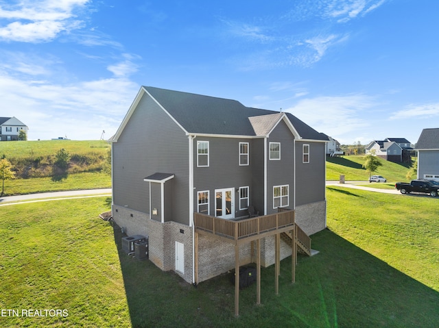 rear view of house with a yard and central air condition unit