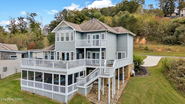 rear view of house featuring a balcony, a wooden deck, a yard, and central air condition unit