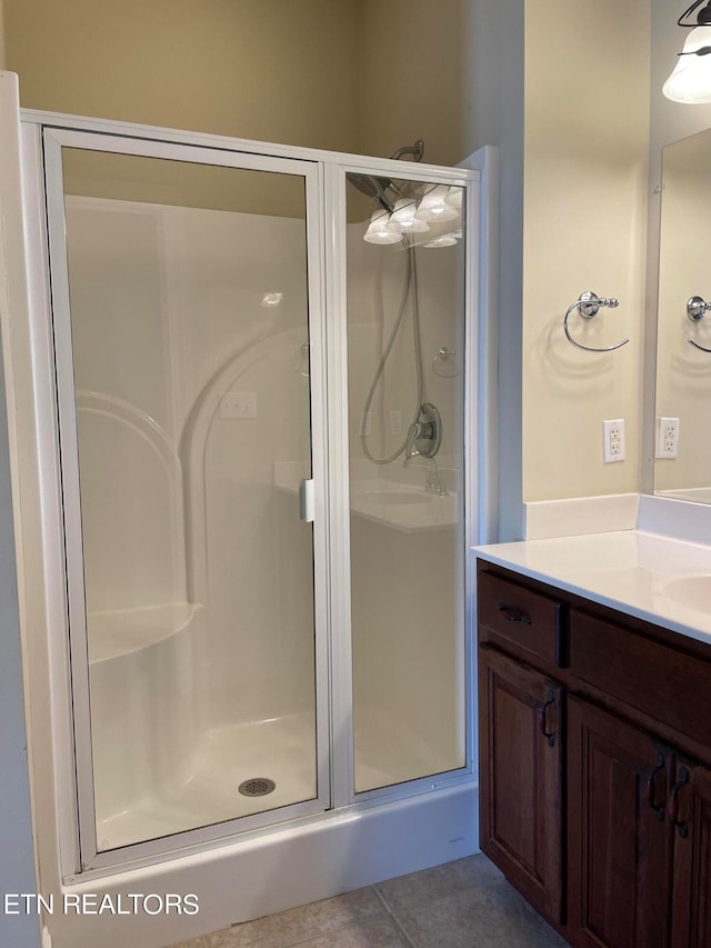 bathroom with vanity, walk in shower, and tile patterned flooring