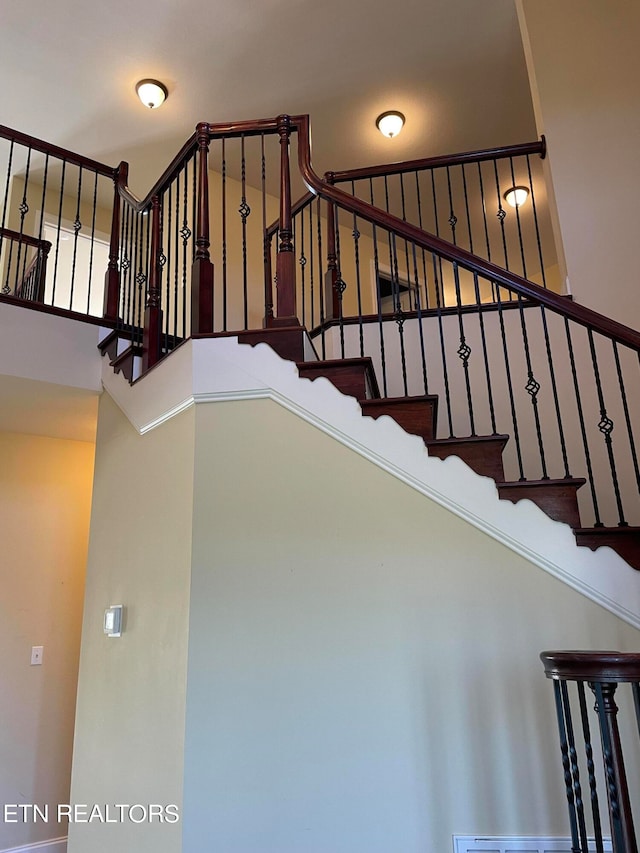 staircase featuring a towering ceiling