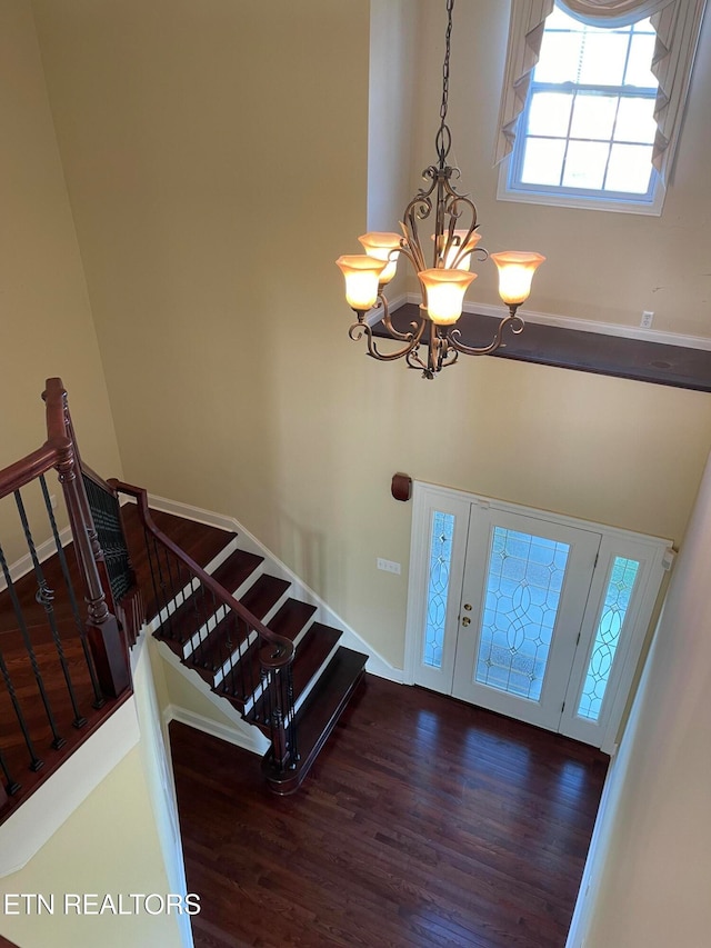 entrance foyer with a high ceiling, an inviting chandelier, and dark hardwood / wood-style floors