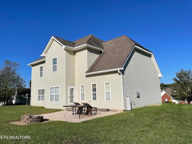 back of house with an outdoor fire pit, a patio, and a lawn