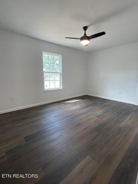 unfurnished room featuring dark hardwood / wood-style floors and ceiling fan