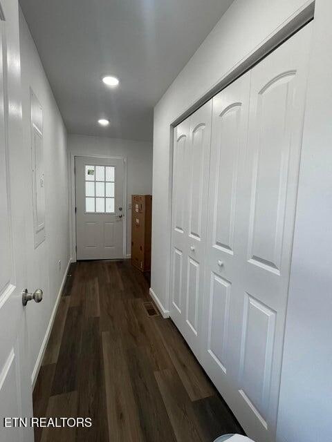 hallway with dark hardwood / wood-style flooring