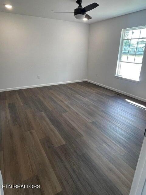 empty room featuring ceiling fan and dark hardwood / wood-style flooring