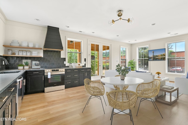 kitchen with a wealth of natural light, light hardwood / wood-style flooring, custom range hood, and range