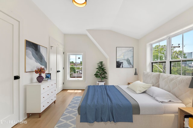 bedroom with vaulted ceiling and light hardwood / wood-style flooring