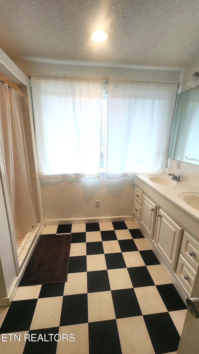 bathroom featuring vanity, a textured ceiling, and walk in shower