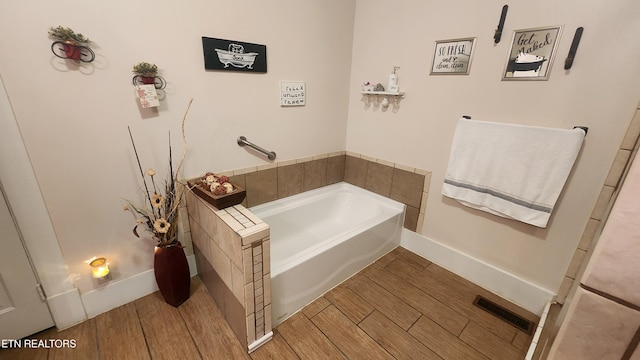 bathroom with a bathtub and hardwood / wood-style floors