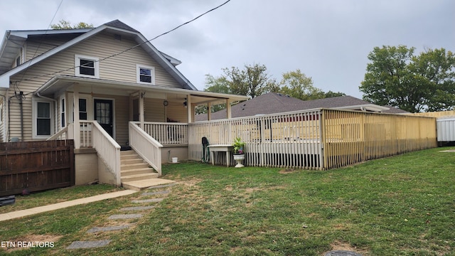 rear view of property with a yard and a porch