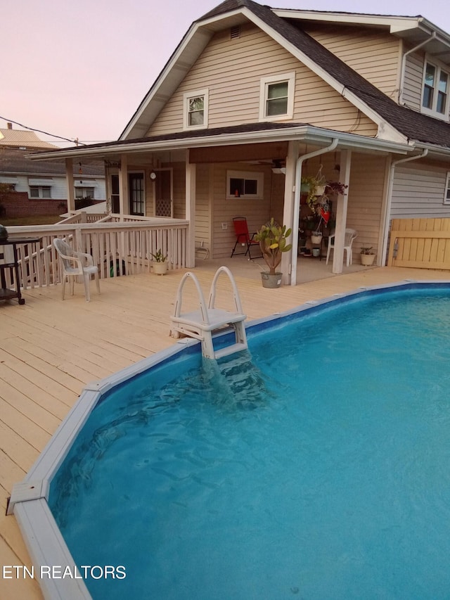 pool at dusk with a wooden deck