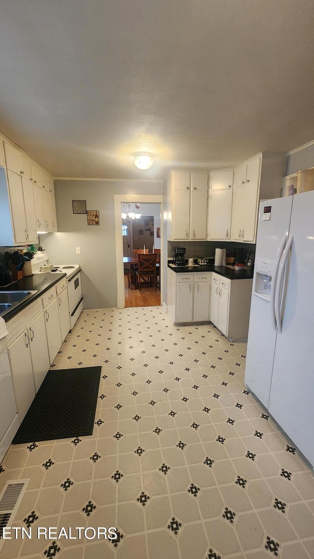 kitchen featuring sink, decorative backsplash, white cabinets, and white appliances