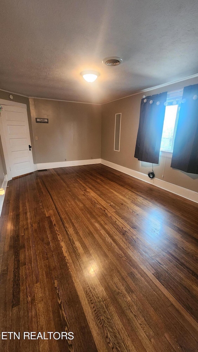 empty room featuring a textured ceiling and wood-type flooring