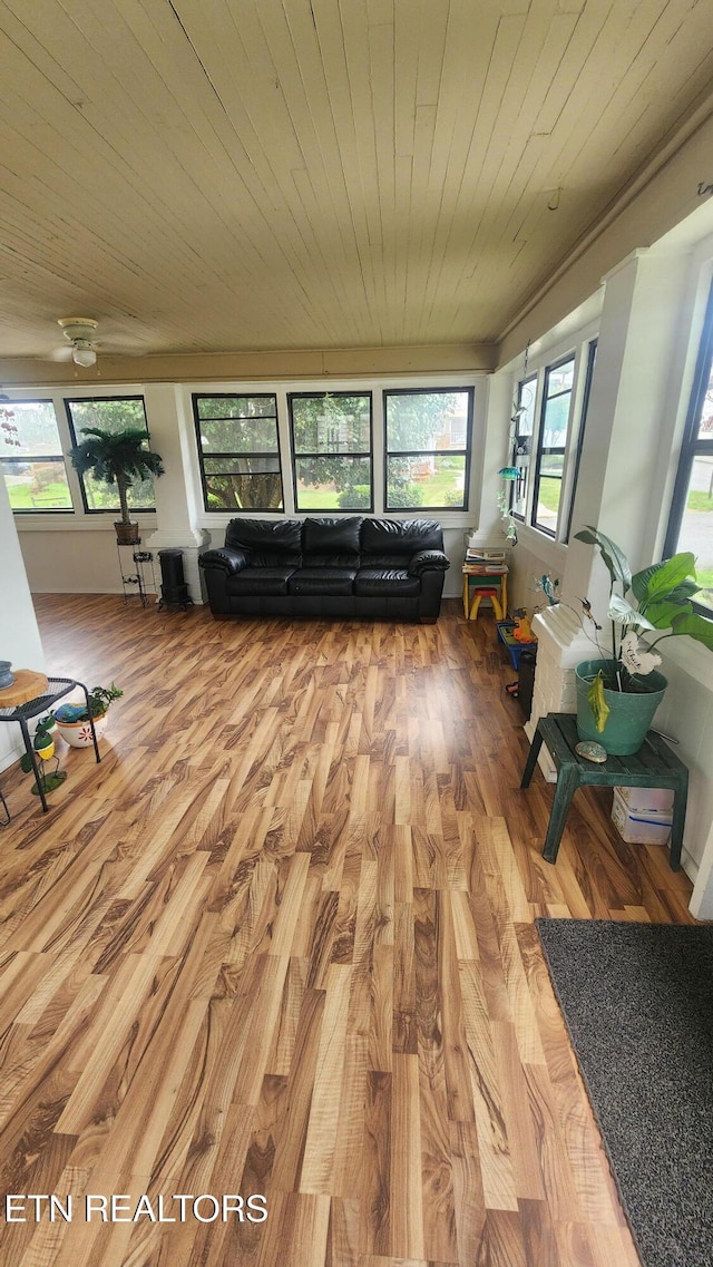 interior space with light hardwood / wood-style flooring, wood ceiling, and plenty of natural light