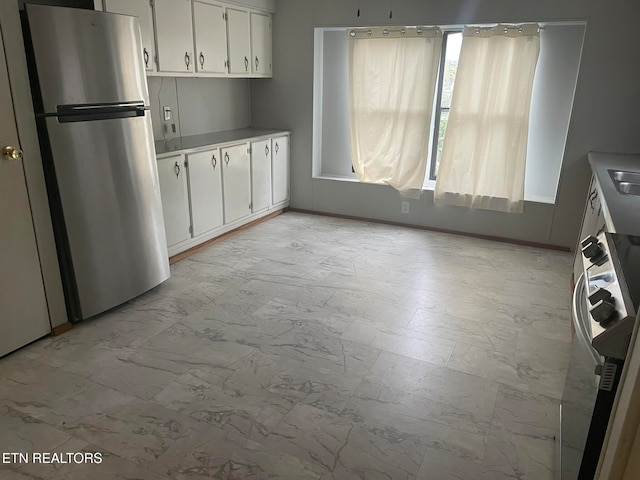 kitchen with stainless steel fridge and white cabinetry