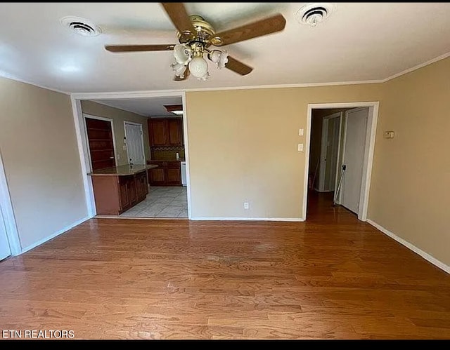 unfurnished room featuring light hardwood / wood-style floors, crown molding, and ceiling fan