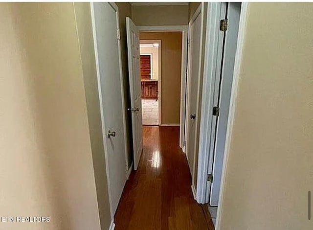 hallway with dark hardwood / wood-style flooring