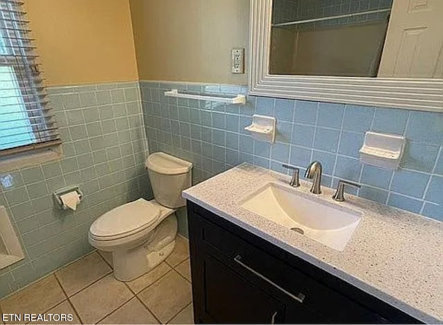 bathroom featuring tile walls, vanity, toilet, and tile patterned flooring