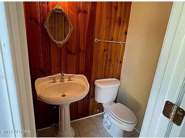 bathroom featuring toilet, wood walls, and tile patterned flooring