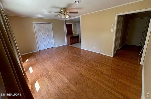 unfurnished bedroom with ornamental molding, dark wood-type flooring, a closet, and ceiling fan